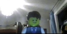 a green lego man in a suit and tie is holding a tablet