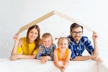 a family is posing for a picture under a cardboard roof .