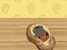 a peanut with a cartoon face on it is sitting on a wooden table .