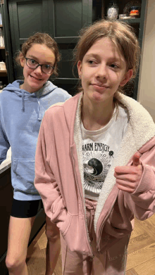 two girls standing next to each other one wearing a warm energy t-shirt