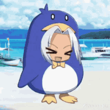 a cartoon character dressed as a penguin is standing on a beach .