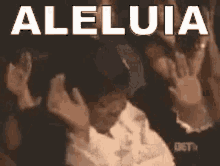 a group of people are sitting in a dark room with the word aleluia written in white letters on a black background .