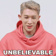 a man wearing a pink hoodie with the word unbelievable written on it