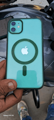 a person is holding a green iphone with a green case