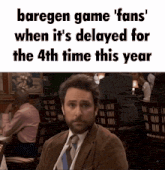 a man in a suit and tie is sitting at a table with a caption that says baregen game fans