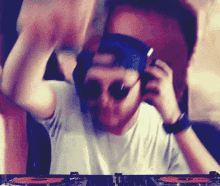 a man wearing sunglasses and headphones is playing music on a turntable