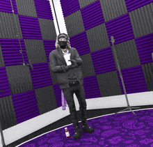 a man standing in a room with purple walls and a bottle of ketchup on the floor