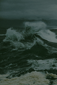 a stormy ocean with waves crashing against a rocky shore