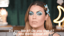 a woman with blue eyeshadow is asking do you like it do you love it and do you wanna wear it