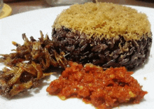 a close up of a plate of food with rice and sauce on it