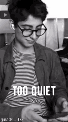 a black and white photo of a young man with glasses and the words too quiet