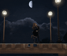 a couple kissing on a bridge at night with a half moon in the background