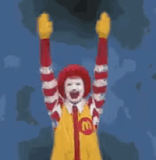 a mcdonald 's clown is holding his arms up in the air