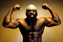 a shirtless man with a beard and a bandana on his head is flexing his muscles