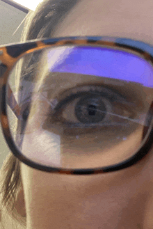 a close up of a woman wearing glasses with a blue lens