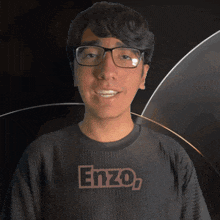 a young man wearing glasses and a shirt that says enzo on it