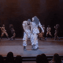 a man and a woman are dancing on a stage in front of an audience
