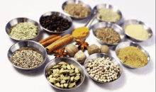 a variety of spices are in metal bowls on a white surface