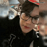a close up of a person wearing glasses and a hat with the letters jn on it
