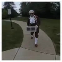 a man in a costume is walking down a sidewalk carrying a box
