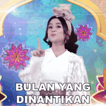 a woman giving a thumbs up with the words bulan yang dinantikan above her