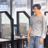 a young man is standing in front of a glass door in a building .
