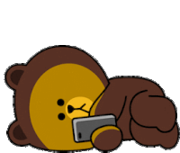 a brown teddy bear is laying down and holding a cell phone