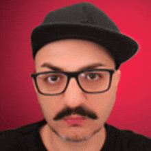 a man with glasses and a mustache is wearing a hat