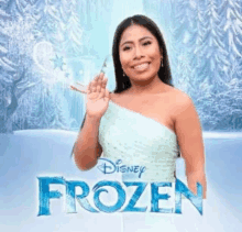 a woman in a blue dress is standing in front of a disney frozen poster