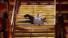 a man is laying on top of a set of stairs with his legs crossed .