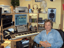 a man sits at a desk with a keyboard and a computer with a screen that says ' yamaha ' on it