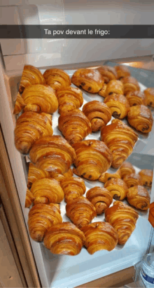 a bunch of croissants are in a refrigerator with a caption that says ta pov devant le frigo