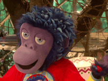 a stuffed monkey with blue hair and a red shirt