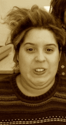 a woman making a funny face wearing a sweater