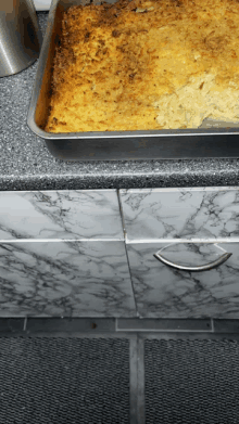 a casserole dish is sitting on a marble counter top