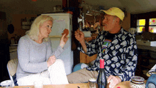 a man and a woman sit at a table in front of a refrigerator that has the word lucky on it