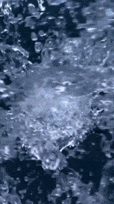 a close up of water splashing on a dark surface