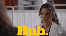 a woman in a lab coat is talking to another woman and the words huh are visible