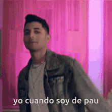 a man in a denim jacket is dancing in front of a pink background with the words yo cuando soy de pau above him