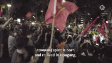 a crowd of people holding flags with the words kampong spirit is born and re-lived in hougang on the bottom