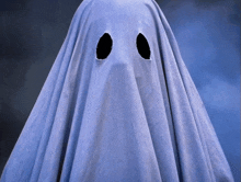 a ghost covered in a white sheet with two holes in it 's eyes