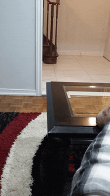 a person sitting on a couch in a living room with stairs in the background