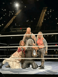 a group of wrestlers posing for a picture in a ring