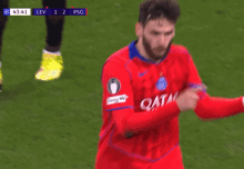 a soccer player wearing a red jersey with the word qatar on the front