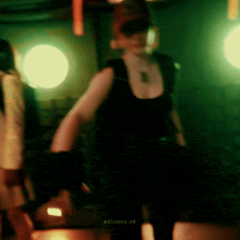 a blurry photo of a woman in a black tank top with editmen 06 written on the bottom