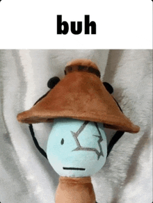 a stuffed animal wearing a brown hat with the word " buh " above it