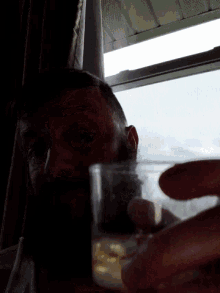 a man with a beard is drinking from a small glass