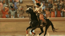 a man riding a horse in front of a crowd of people