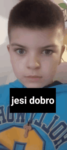 a young boy wearing a blue hoodie with the word jesi dobro on it