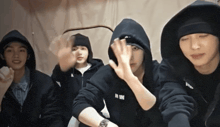 a group of young men wearing black hoodies and beanies with the letters mm on the front